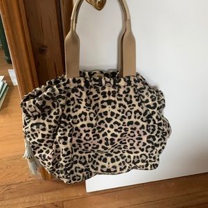 India Hicks tote with two leather tassels and leather handles.